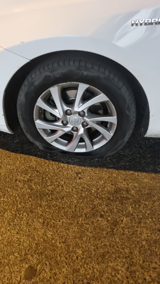 צמיג מרוקן בחניה בערב. ברוב המקרים מדובר במסמר או בורג, ואפשר לתקן במקום.