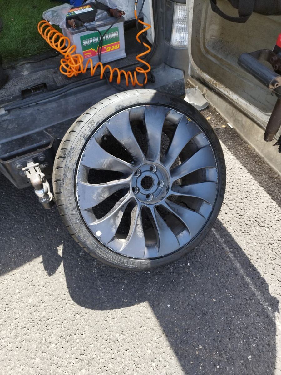 גלגל של טסלה עם צמיג Michelin Pilot Sport, מפורק ליד רכב השירות לפני החלפה.