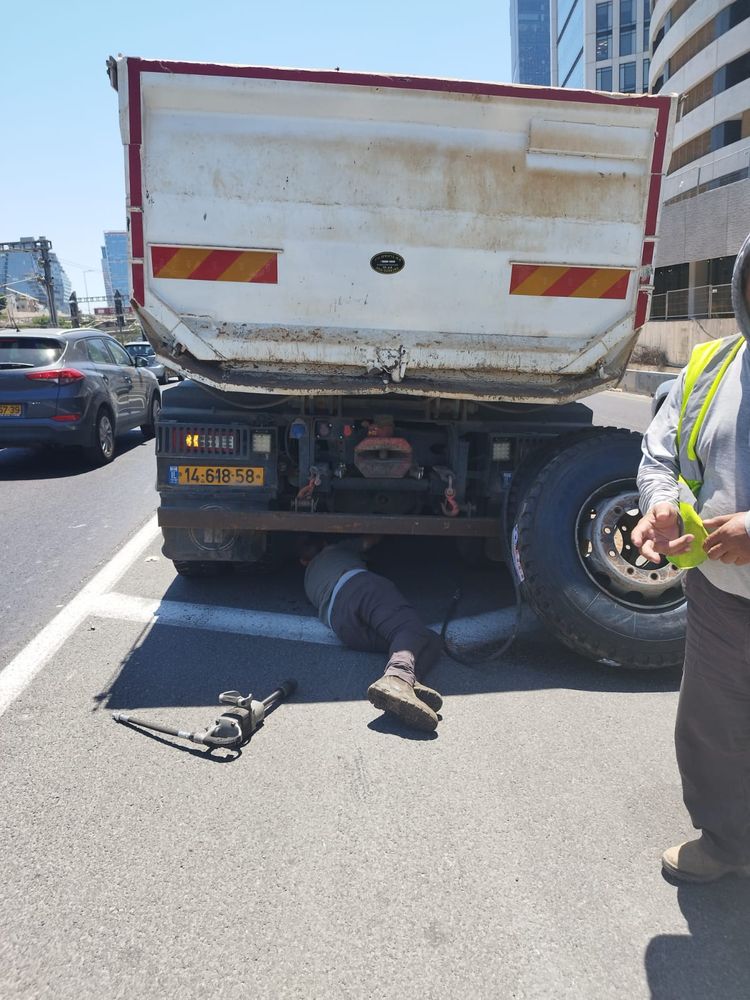 משאית רכינה בצד הכביש בזמן החלפת גלגל