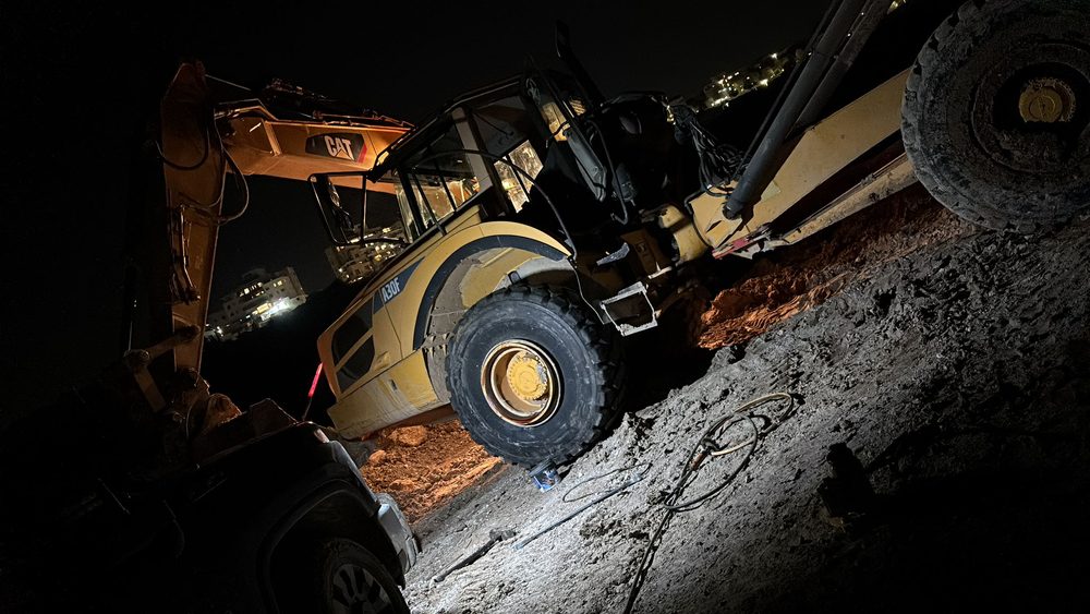 מחפרון בשטח משופע בלילה, במהלך העבודה על הגלגל
